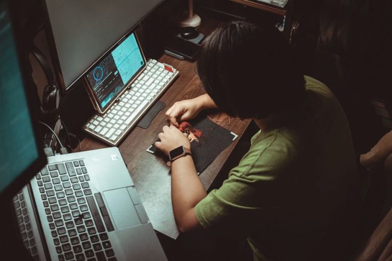 дизайнер работает с Adobe InDesign на компьютере